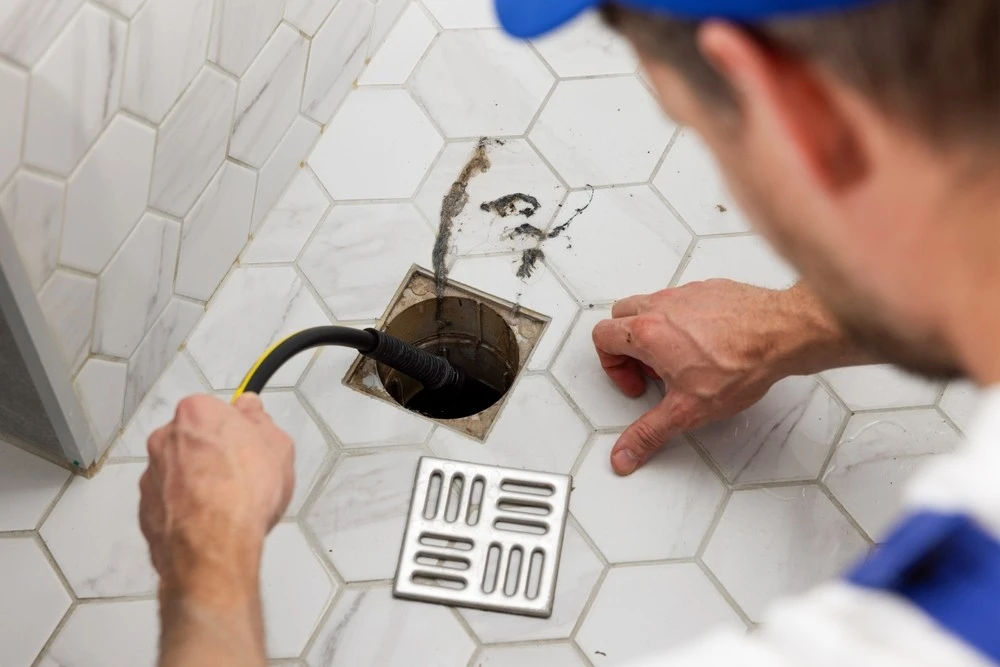 plumber-unclogging-blocked-shower-drain-hydro-jetting