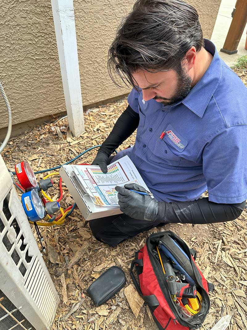 Technician recording system readings while performing AC repair in Vacaville, CA