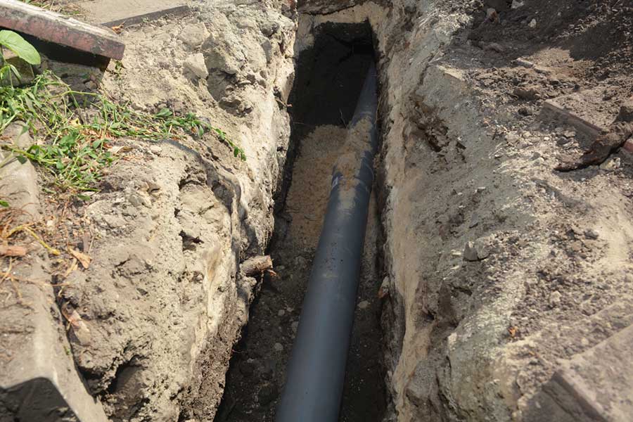 Residential drain pipe repair showing a replacement pipe laid in a deep trench in Vacaville, CA