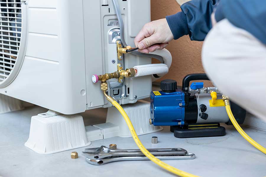 Technician servicing an outdoor HVAC unit during emergency HVAC repair in Vacaville, CA