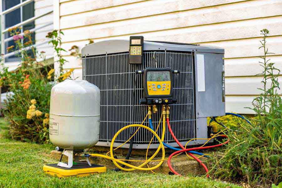 Residential AC condenser with diagnostic testing equipment attached during professional AC maintenance service