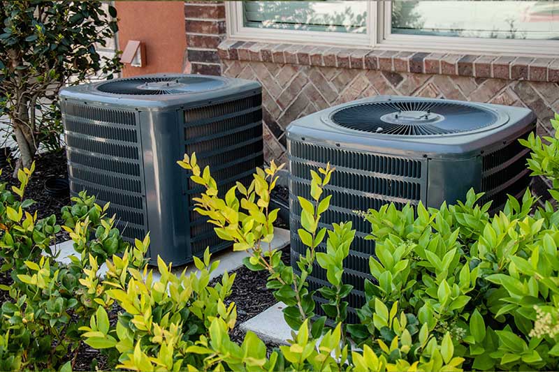 Residential AC condensers positioned outside a home for routine AC tune-up in Vacaville, CA