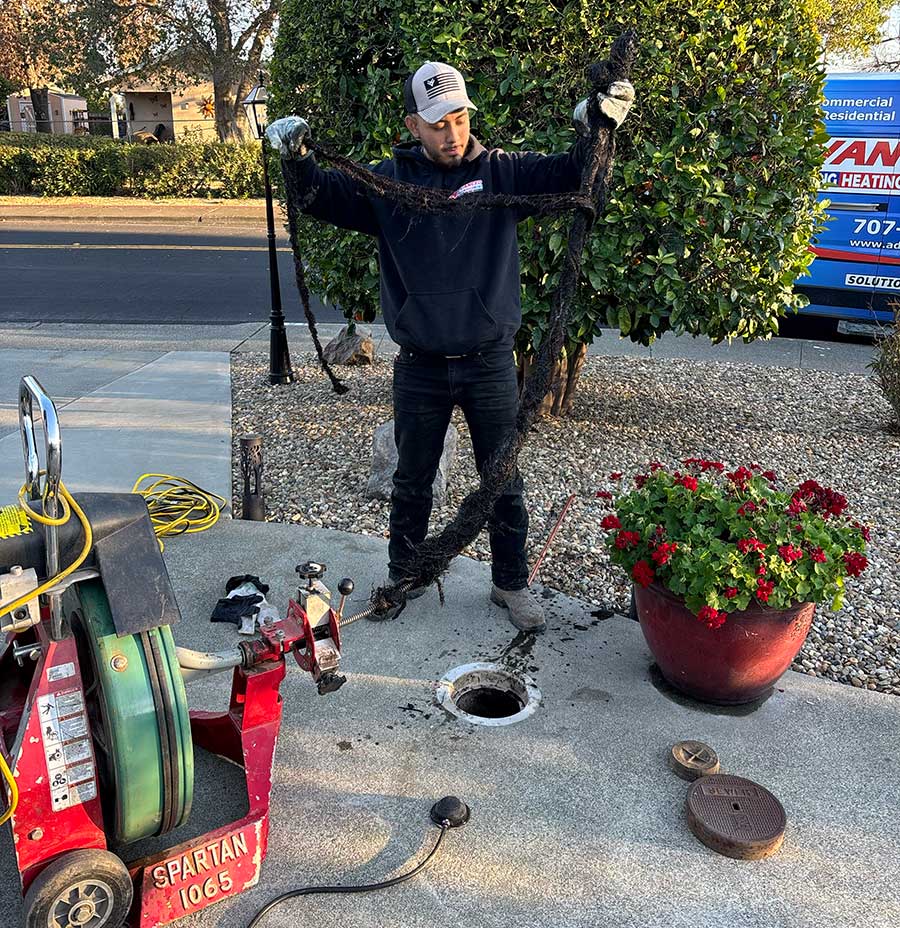 Plumber inspecting a drain line after removing a long buildup of roots and debris in Vacaville, CA