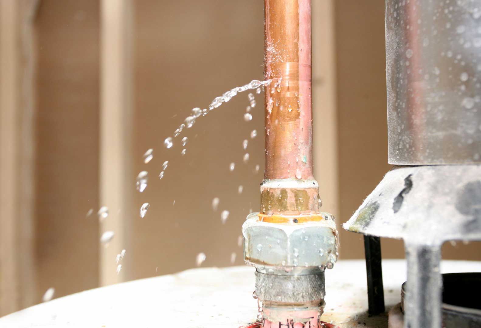 Burst copper pipe spraying water during a plumbing emergency in Vacaville, CA