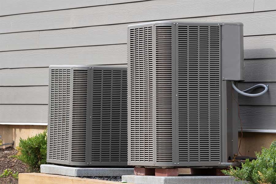 Two residential heat pump condenser units installed beside a home in Vacaville, CA